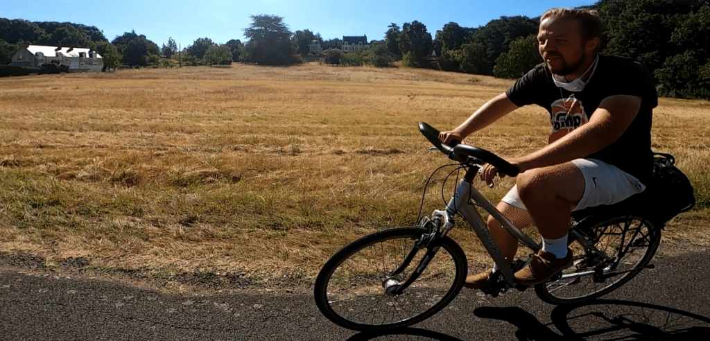 Cyclotouriste en été sur une route de campagne